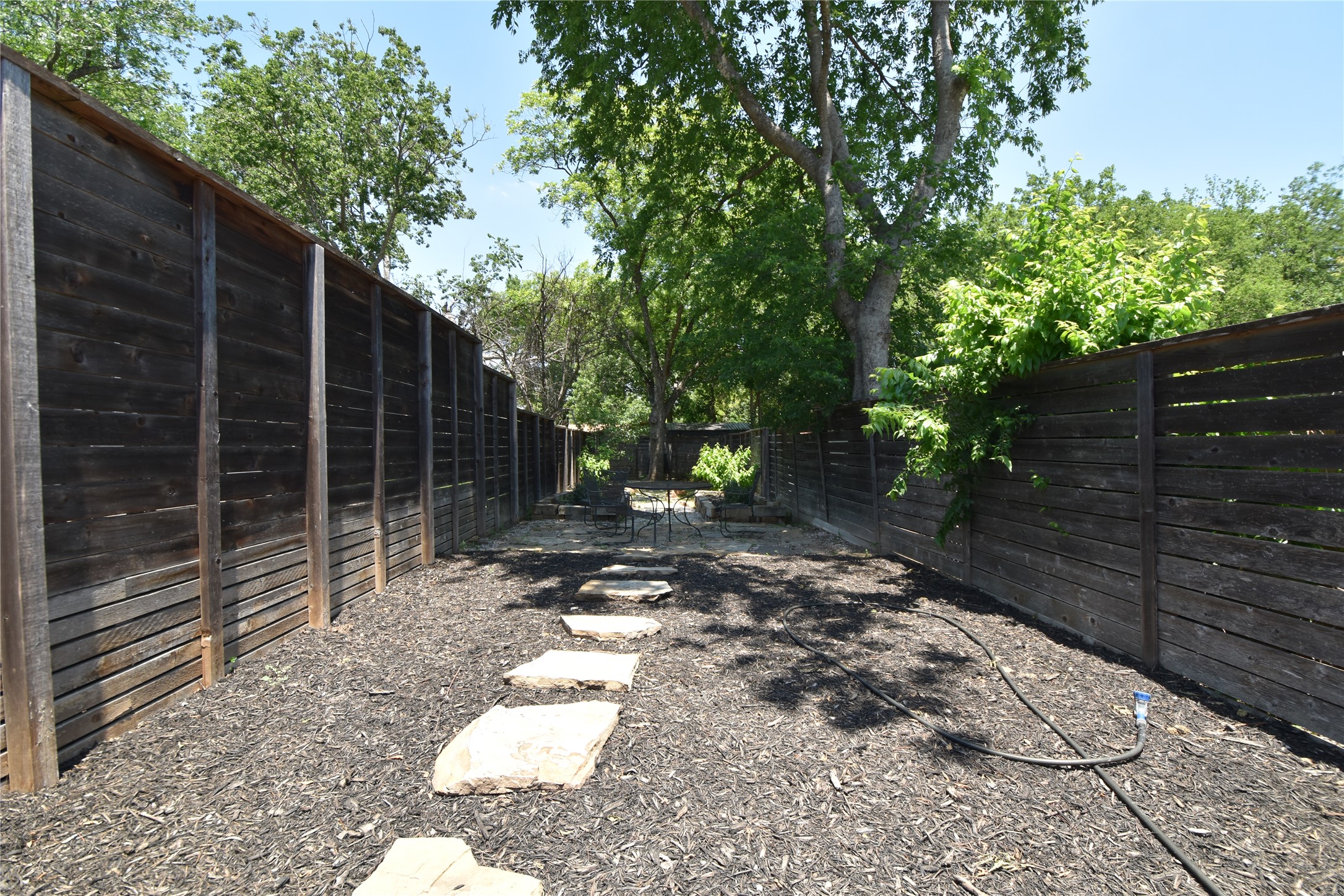2012 Payne Avenue, Unit A Austin, TX 78757 - Photo 28 of 33 Landscaped outdoor area featuring natural stone stepping stones leading to a stone patio and room for outdoor games while the pizza is cooking privacy fencing, and mature trees providing shade