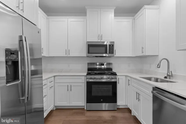 a kitchen with stainless steel appliances granite countertop a refrigerator stove and sink