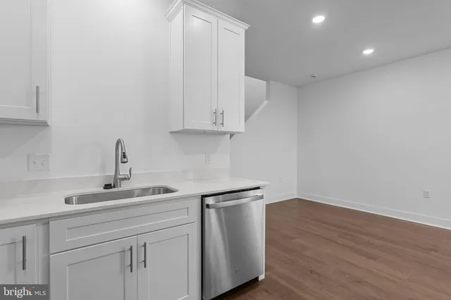 a kitchen with a sink cabinets and wooden floor