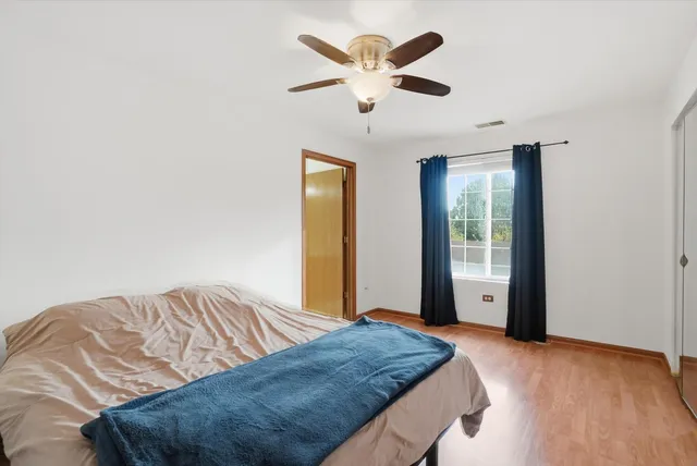a bedroom with a large bed and a ceiling fan