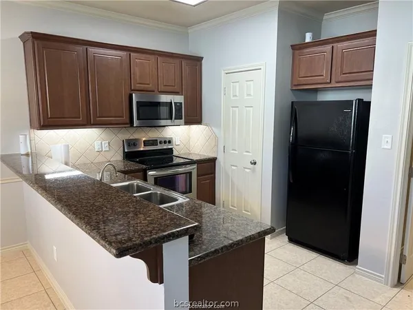 a kitchen with granite countertop stainless steel appliances and wooden cabinets
