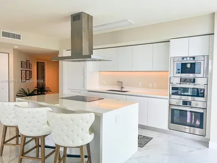 a kitchen with stainless steel appliances granite countertop a sink and a refrigerator