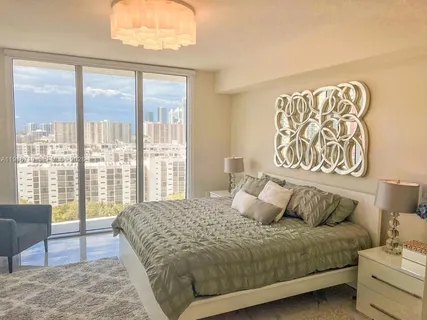 a bedroom with a large bed and a couch next to a window