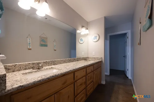 a bathroom with a granite countertop sink and a mirror