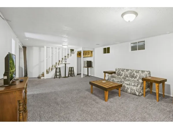a bedroom with a bed a dresser and potted plant