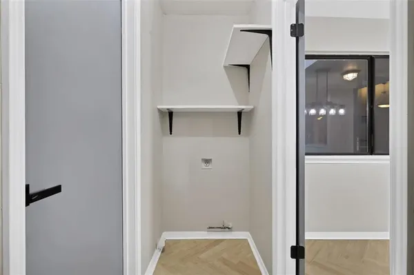 a view of a hallway with wooden floor and a bathroom