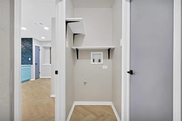 a view of an empty room with chandelier fan