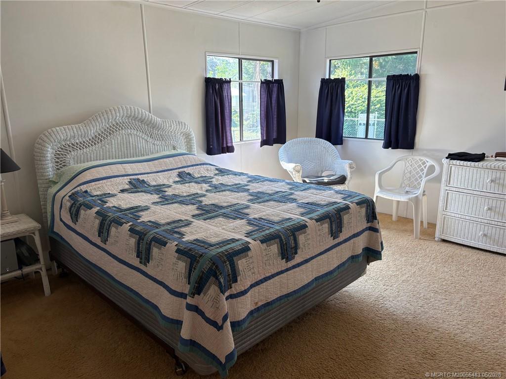 2856 Southwest Toronado Trail Stuart, FL 34997 - Photo 15 of 20 a bed sitting in a bedroom next to a window