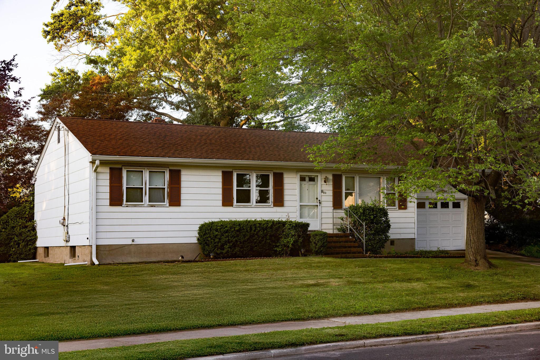 a front view of house with a garden