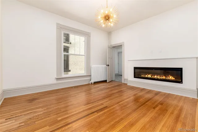 a view of an empty room with a fireplace and a window