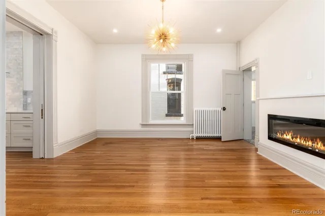 a view of an empty room with window and fire place