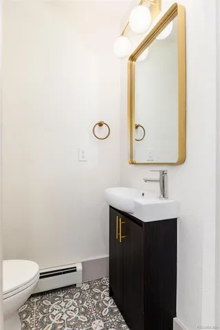 a bathroom with a toilet a sink and mirror