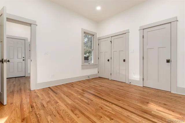 a view of empty room with wooden floor