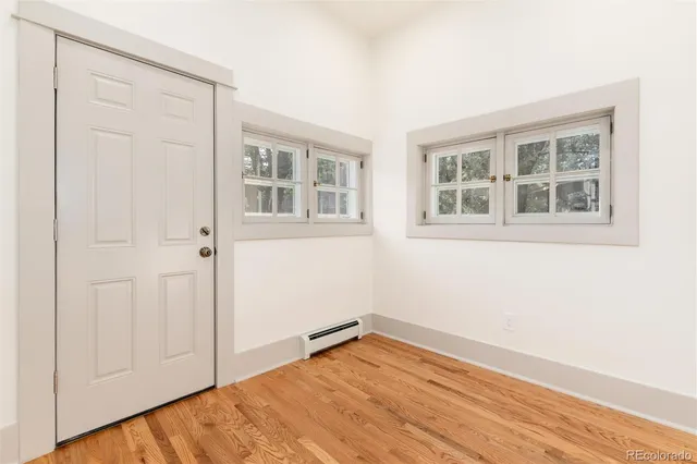 a view of empty room with wooden floor and entryway