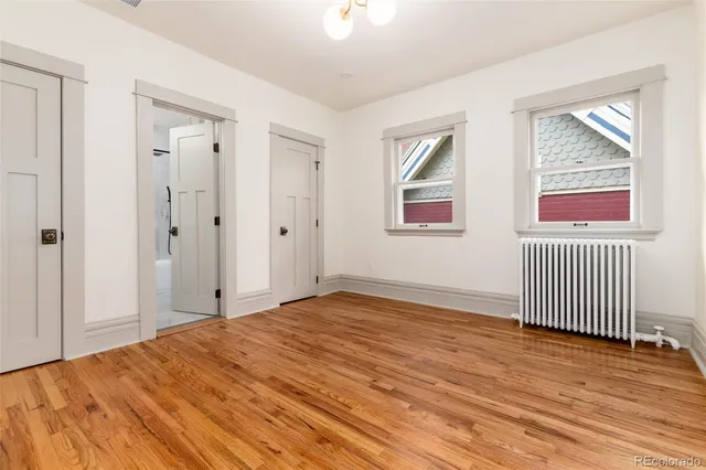 a view of empty room with wooden floor