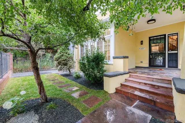 a view of a house with backyard and a tree