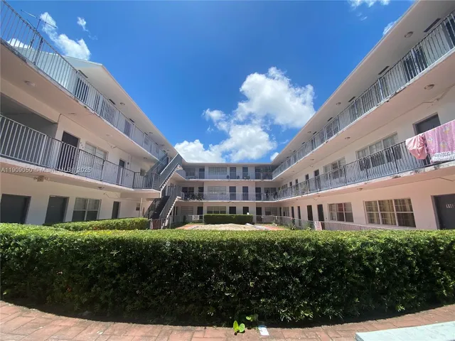 a front view of a building with a garden