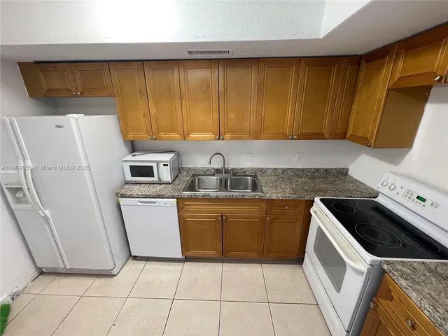 a kitchen with a sink a stove top oven a refrigerator and a sink