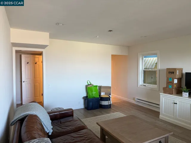a living room with furniture and view of kitchen