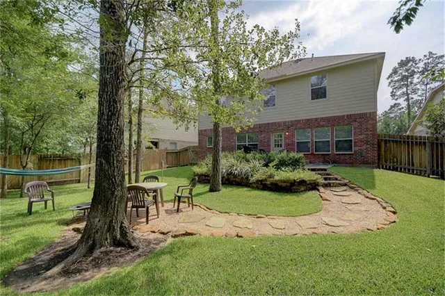 a view of a chair and table in backyard of the house