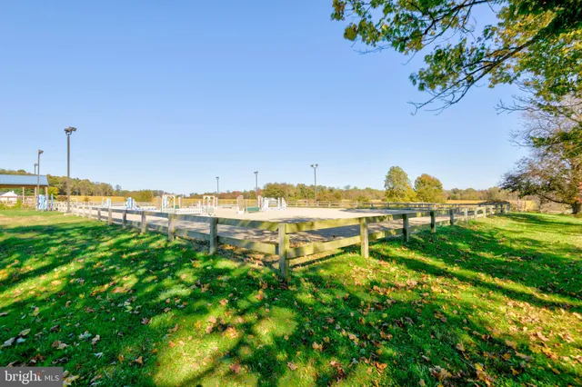 a kitchen with stainless steel appliances a stove a sink a refrigerator a dining table and chairs