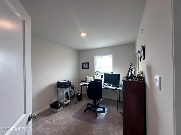 a view of a workspace with furniture and a window