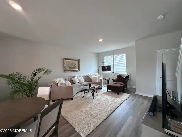 a living room with furniture wooden floor and a flat screen tv