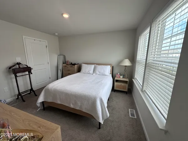 a bedroom with a bed a dresser and a window