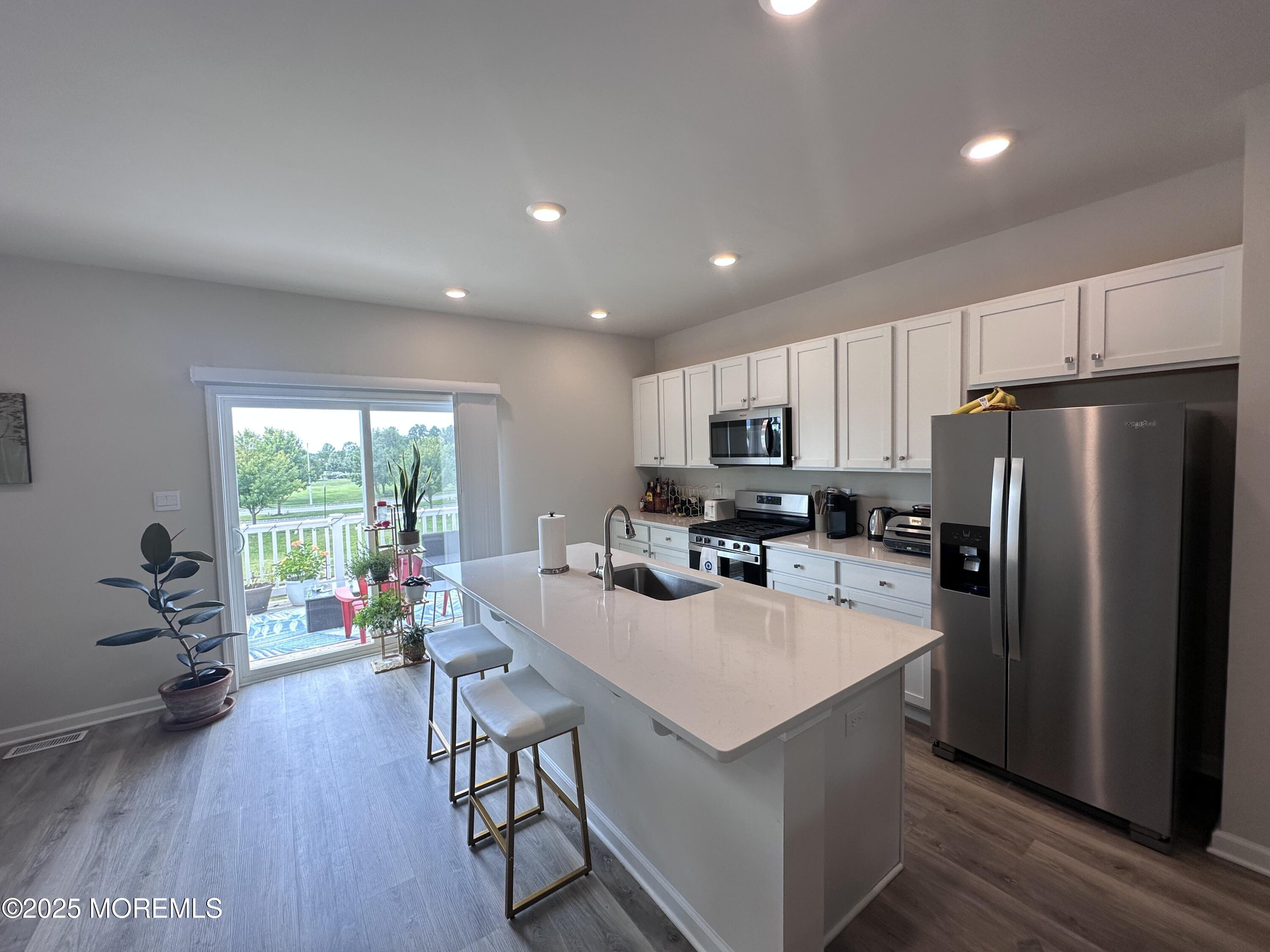 248 Macoun Way Glassboro, NJ 08028 - Photo 4 of 18 a kitchen with a refrigerator a stove a sink dishwasher a dining table and chairs with wooden floor