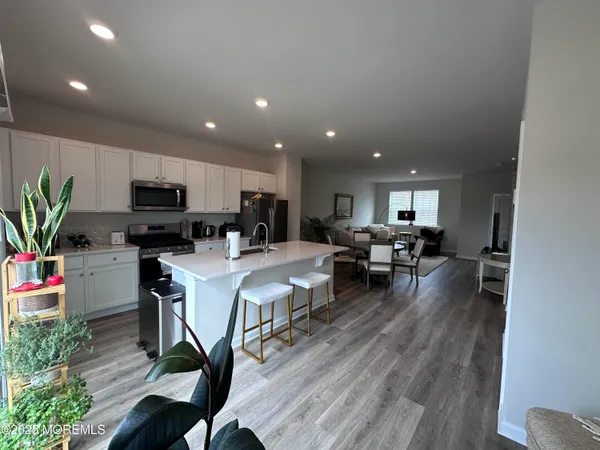 a living room with furniture and a dining table with kitchen view