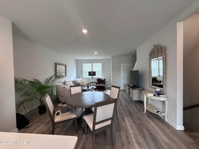 a living room with furniture a wooden floor and a flat screen tv