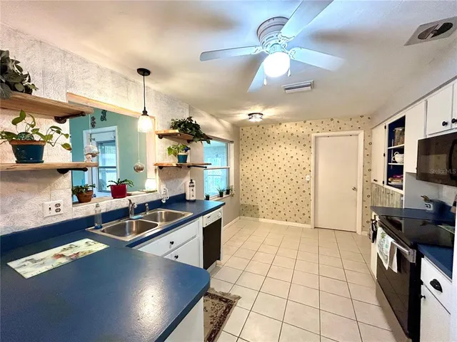a kitchen with kitchen island granite countertop a sink appliances and cabinets