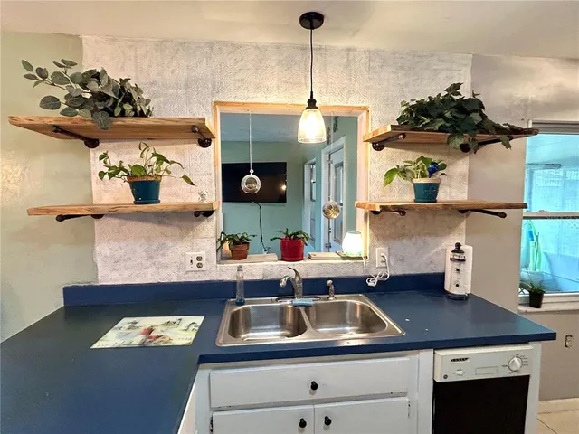 a kitchen with a sink a stove and cabinets