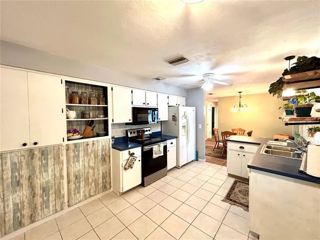 a kitchen with stainless steel appliances a stove a sink a microwave and cabinets
