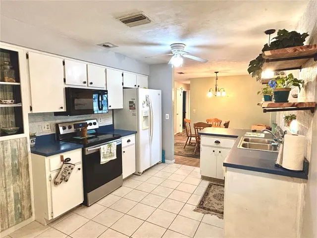 a kitchen with a refrigerator and a stove top oven