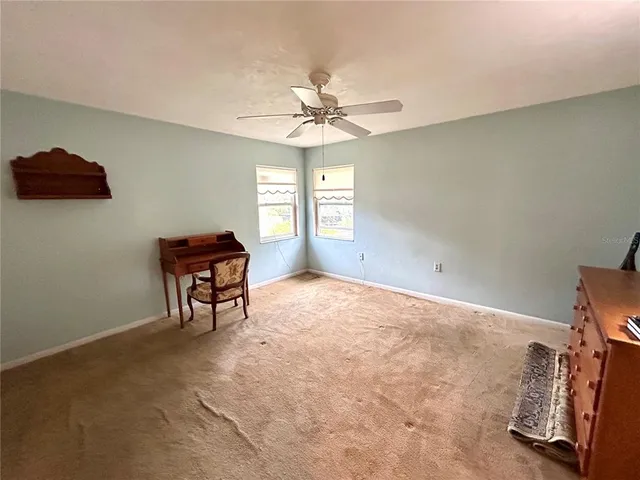 an empty room with windows and ceiling fan