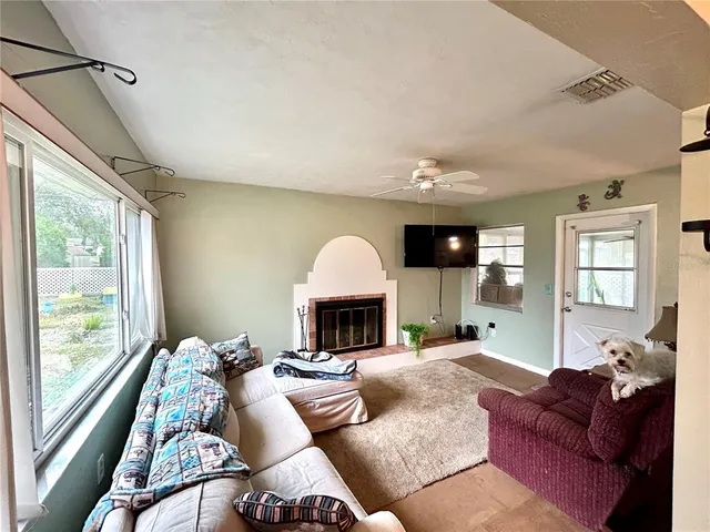 a living room with furniture fireplace and a large window