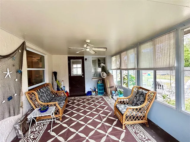 a living room with furniture a fireplace and large windows