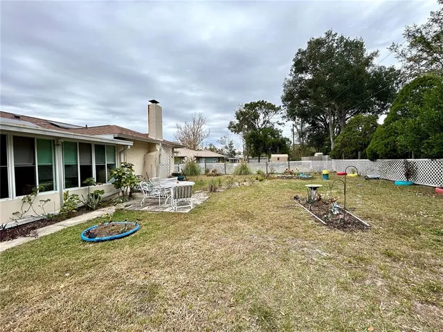 a view of a house with backyard sitting area and garden