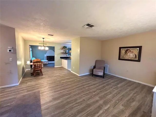 a living room with furniture and a dining table with kitchen view