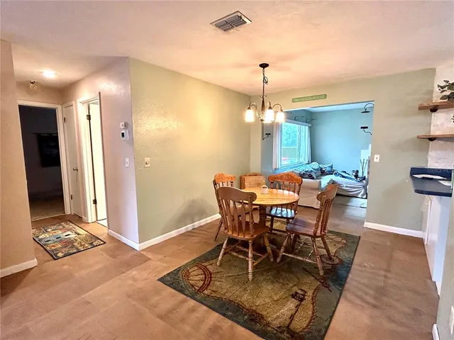 a view of a dining room with furniture and chandelier