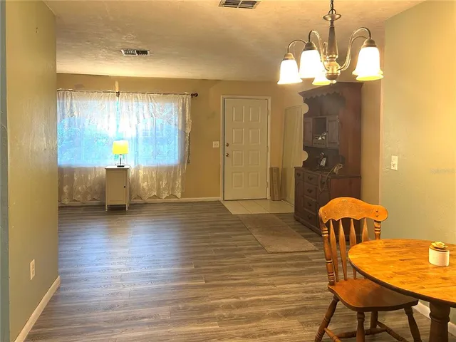 a view of a dining room with furniture and chandelier