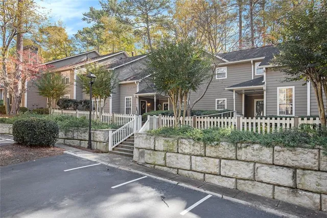 a view of a brick house front and large trees