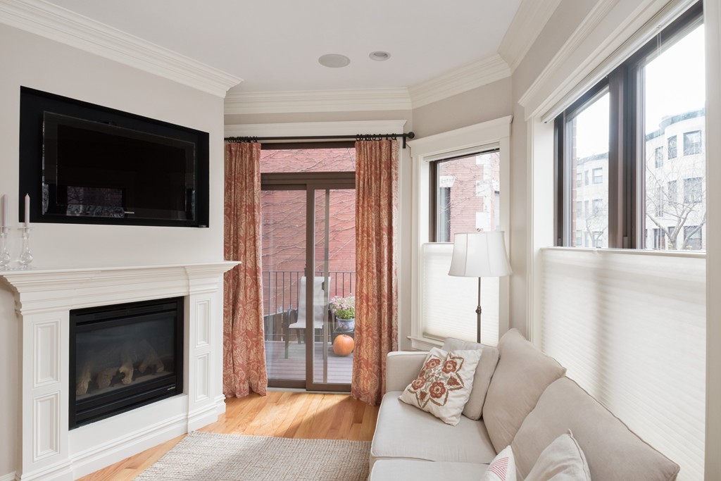 909 Beacon Street, Unit 3 Boston, MA 02215 - Photo 1 of 2 a living room with furniture a flat screen tv and a fireplace