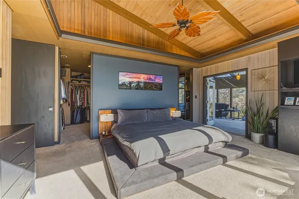 a spacious bedroom with a bed and a flat screen tv