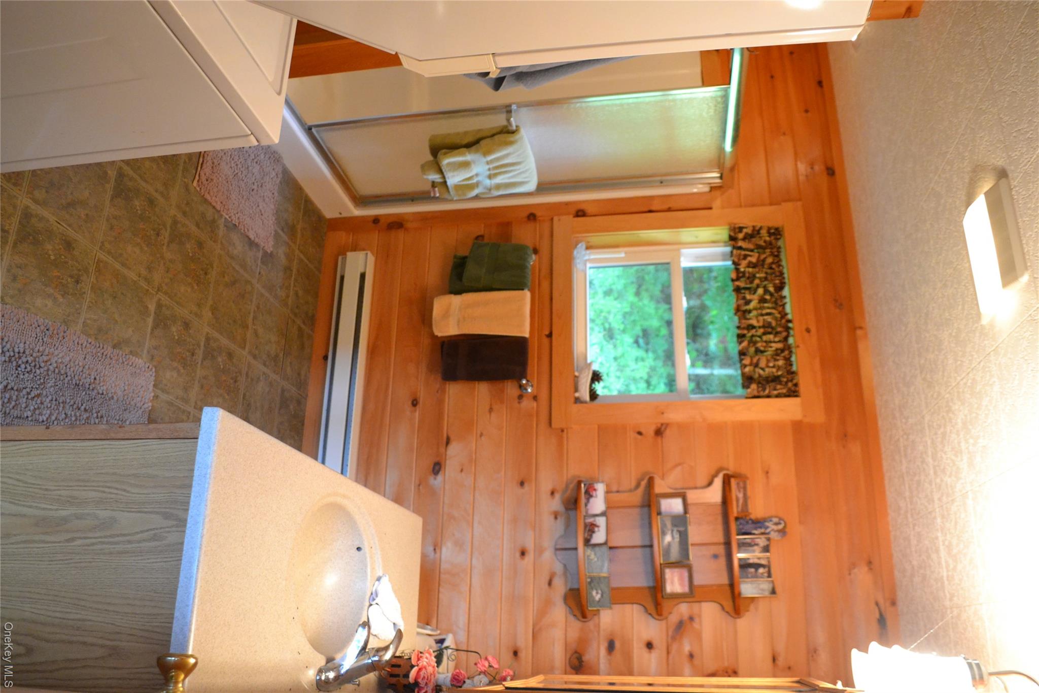 365 Via Appian Way Roscoe, NY 12776 - Photo 24 of 30 Bathroom featuring wood walls, vanity, a shower stall, washer / clothes dryer, and a baseboard heating unit