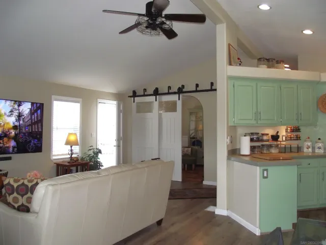 a view of a hallway with wooden floor and cabinet