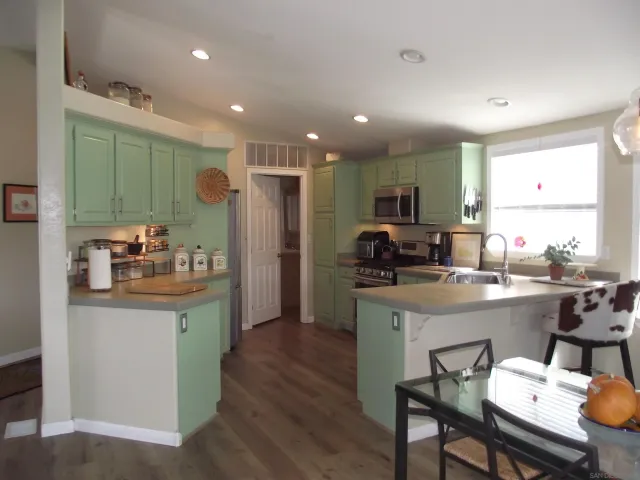 a kitchen with stainless steel appliances granite countertop a refrigerator and a sink