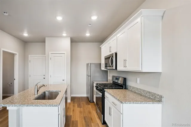 a kitchen that has a lot of cabinets and wooden floor