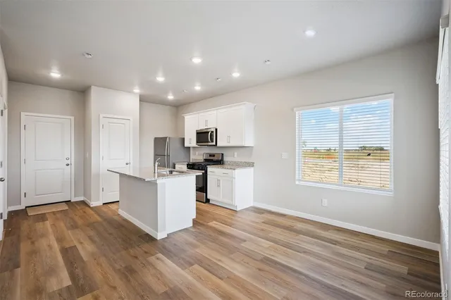 a view of kitchen with wooden floor and electronic appliances